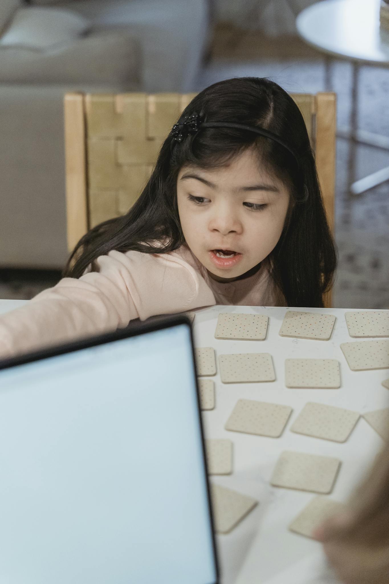 Young girl playing a memory card game at home, focusing on game strategy.